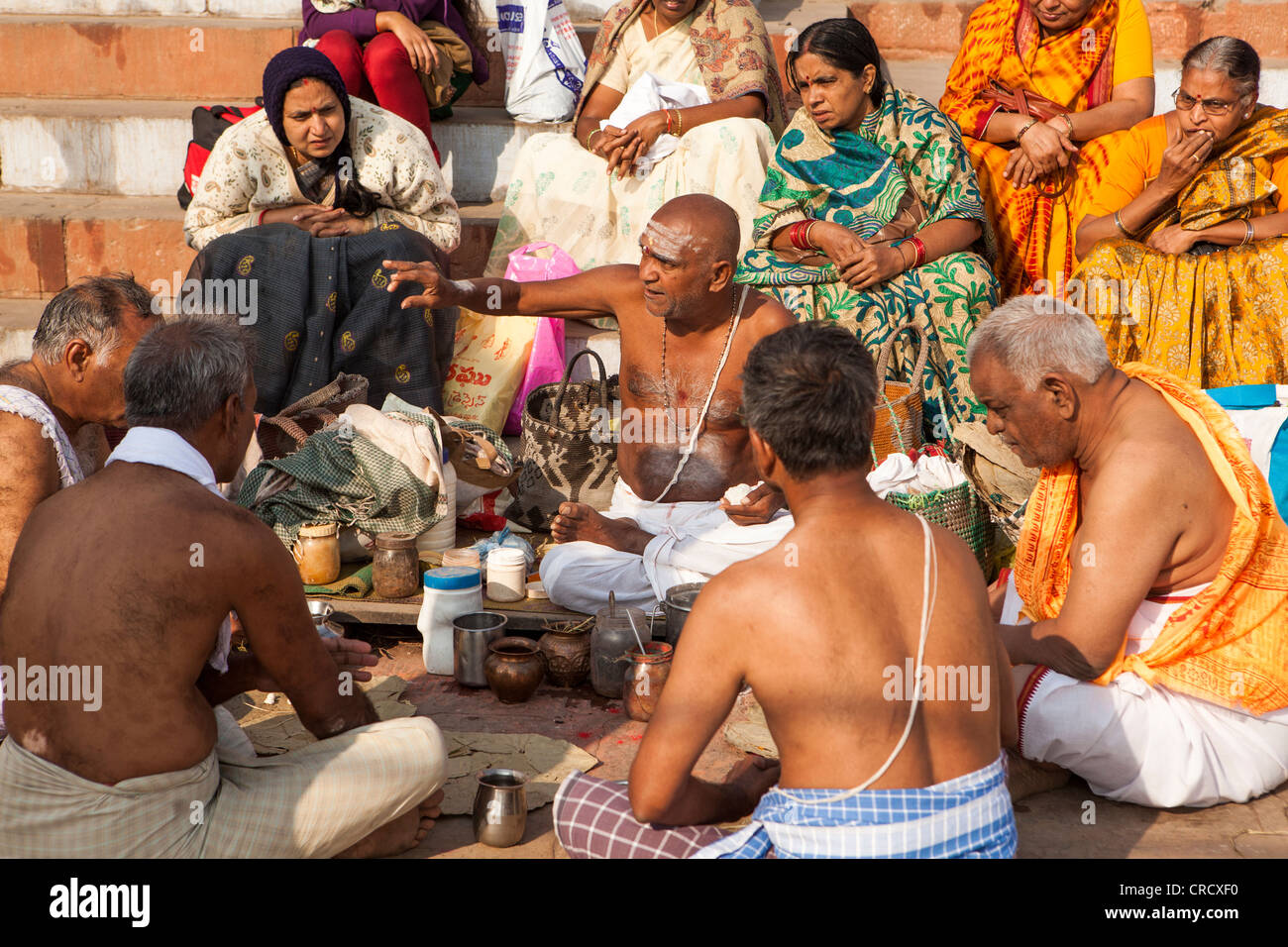 Hindu-Pilger hören Heiligen Wort von Brahman auf das Ghat in Varanasi, Uttar Pradesh, Indien Stockfoto