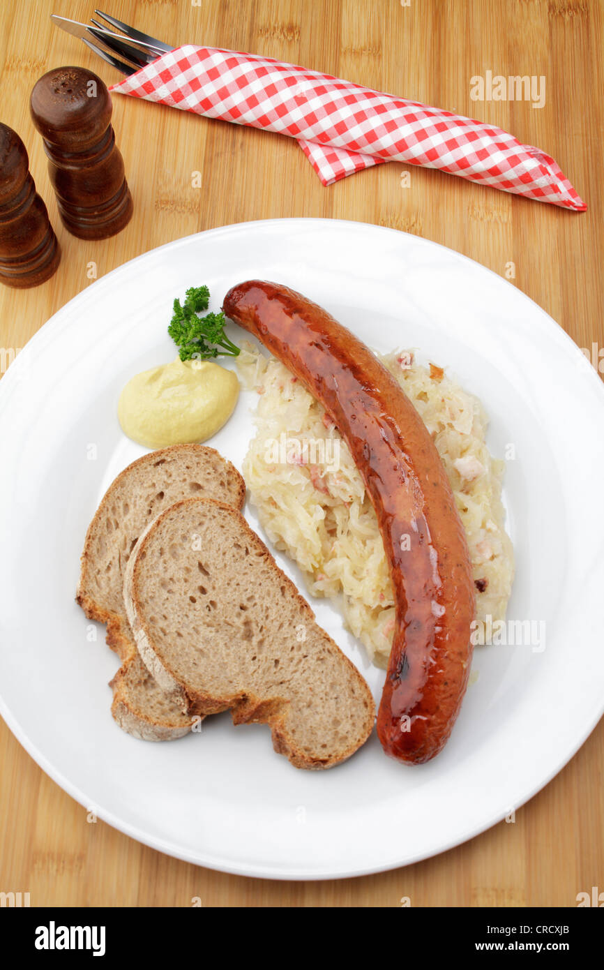 Krakowska geräucherte polnische Chorizo auf Sauerkraut, knusprigem Brot und Senf Stockfoto