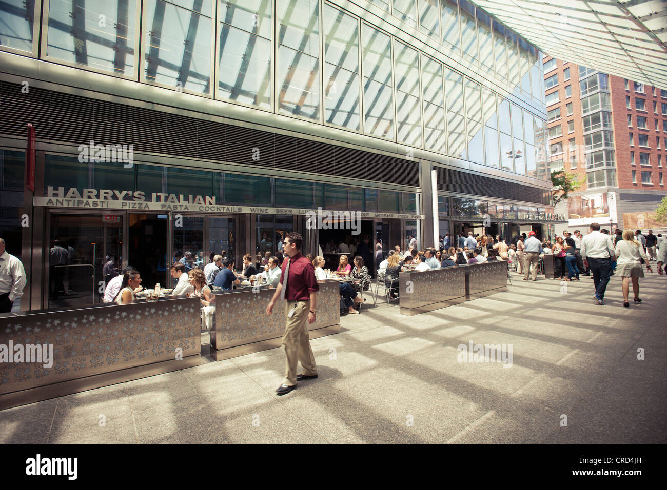 Büroangestellte und Bewohner nutzen das warme saisonale Wetter wie sie auf North End Art in Lower Manhattan in New York laufen Stockfoto