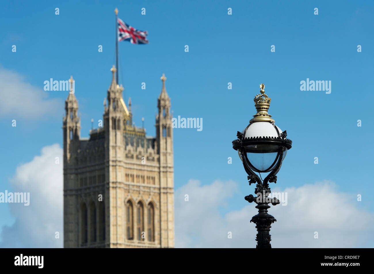 Laternenpfahl am Südufer mit Victoria Tower / Houses of Parliament gegen eine blaue in der Ferne. London, England Stockfoto