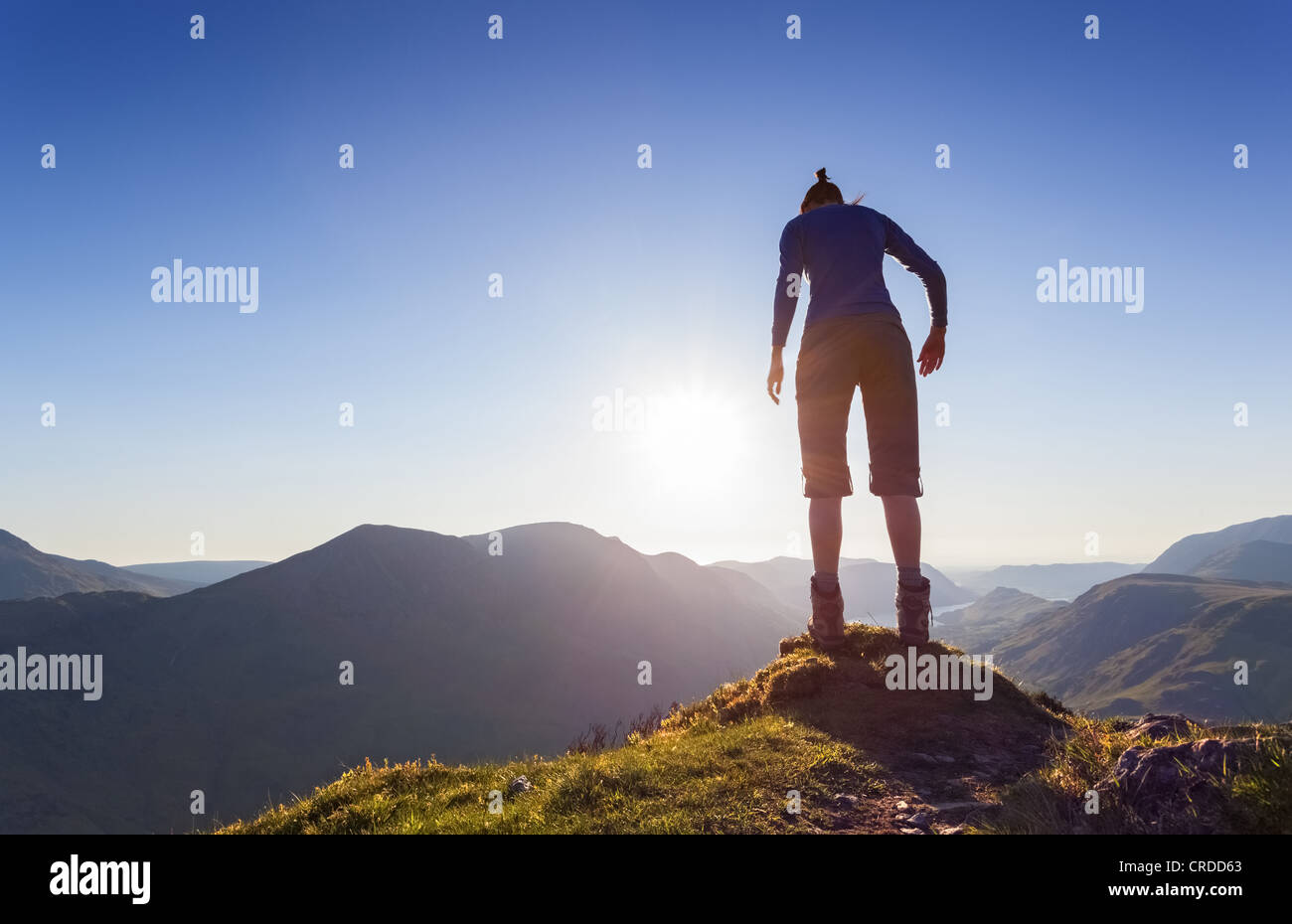 Eine Frau auf dem Gipfel des Fleetwith Pike spähte über den Rand des Berges. Stockfoto