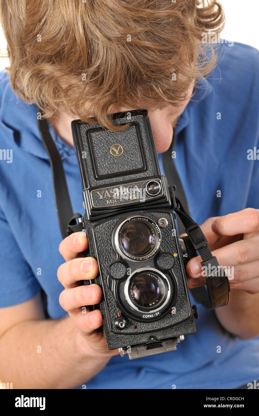 Junger Mann mit dem Fotografieren mit einer analogen 6 x 6 zweiäugigen TLR Kamera Stockfoto