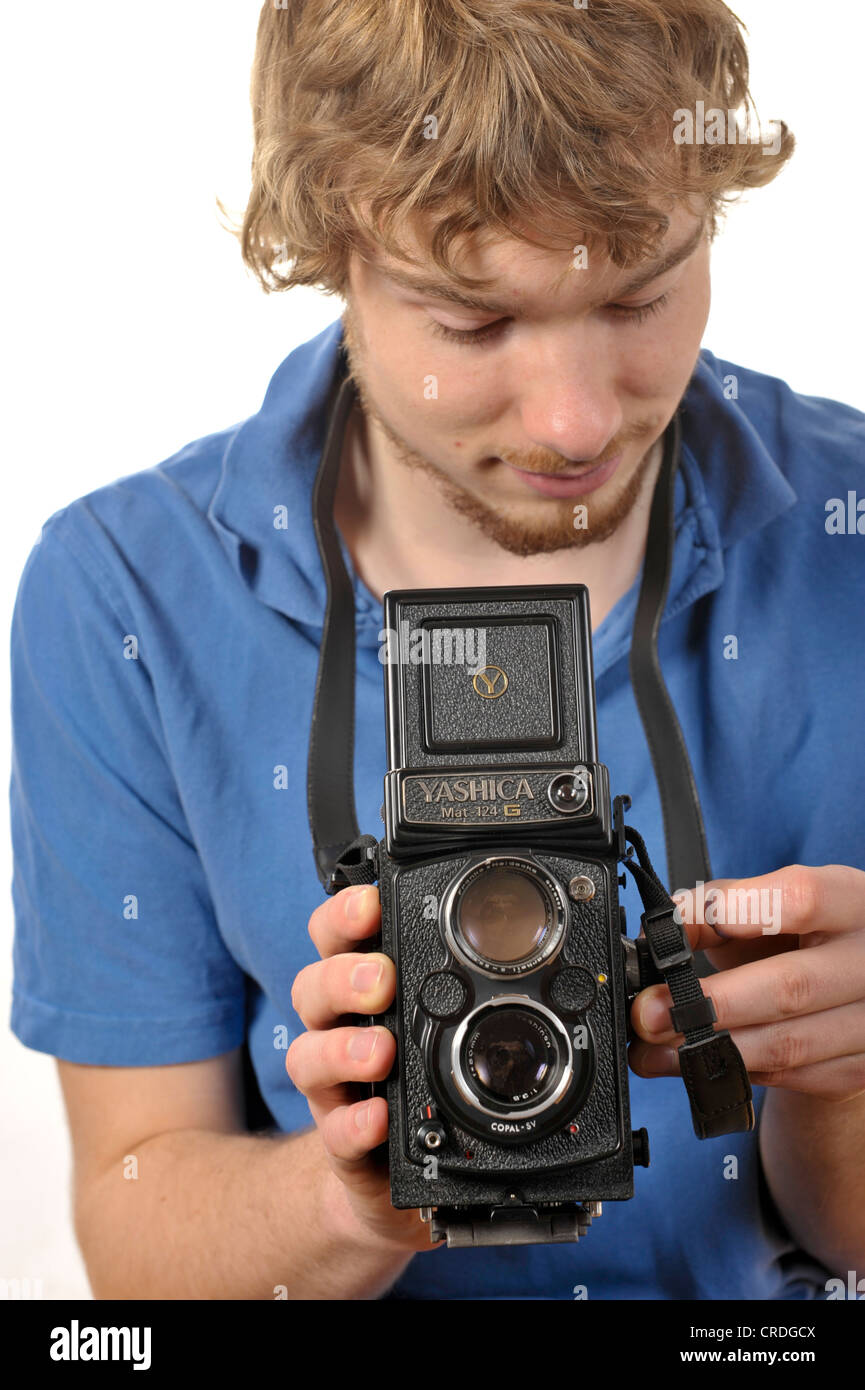Junger Mann mit dem Fotografieren mit einer analogen 6 x 6 zweiäugigen TLR Kamera Stockfoto