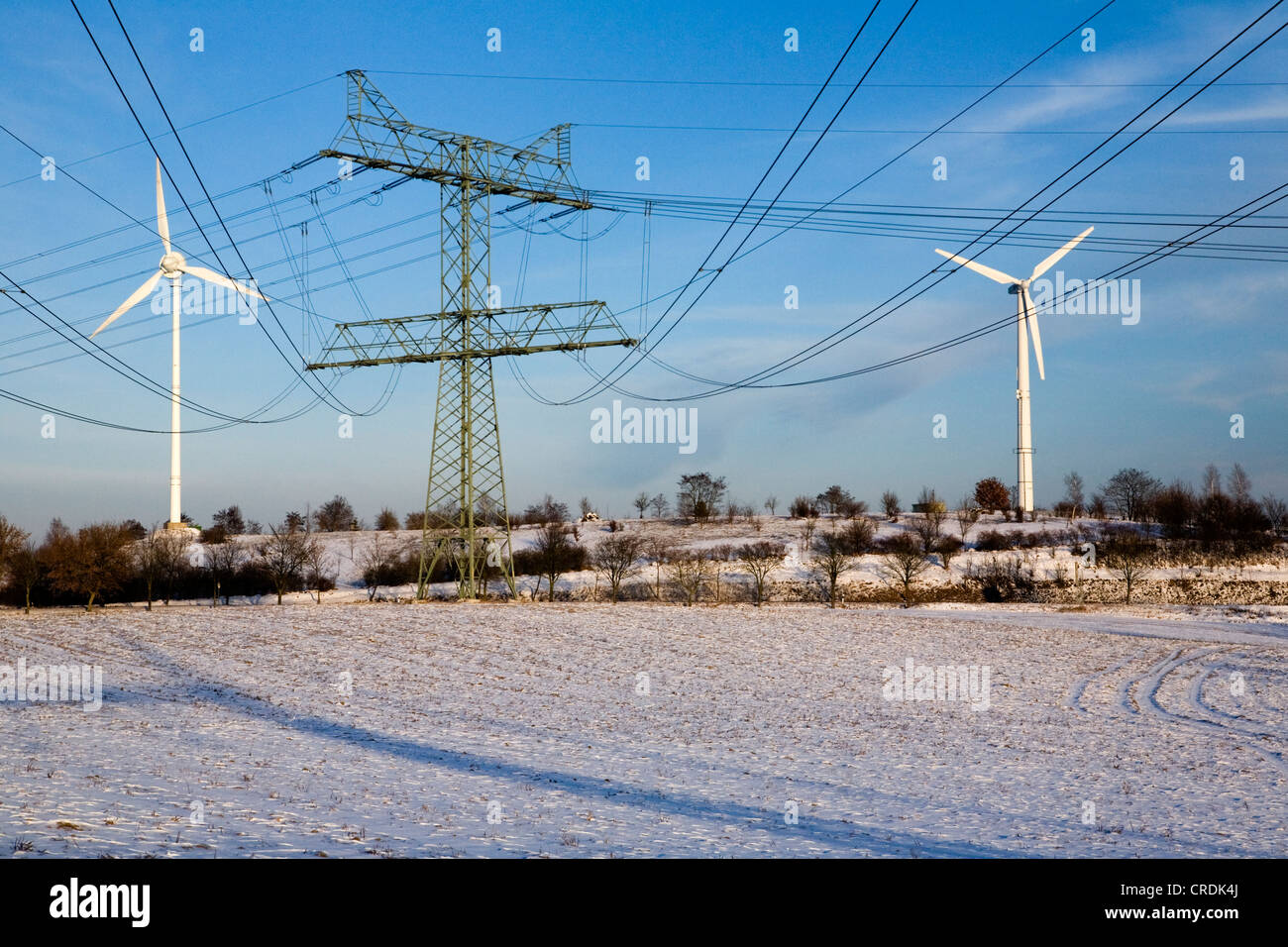 Windkraftanlagen und Strommasten Uckermark-Kraftwerks in einer winterlichen Landschaft, erzeugten Strom Regional durch Stockfoto