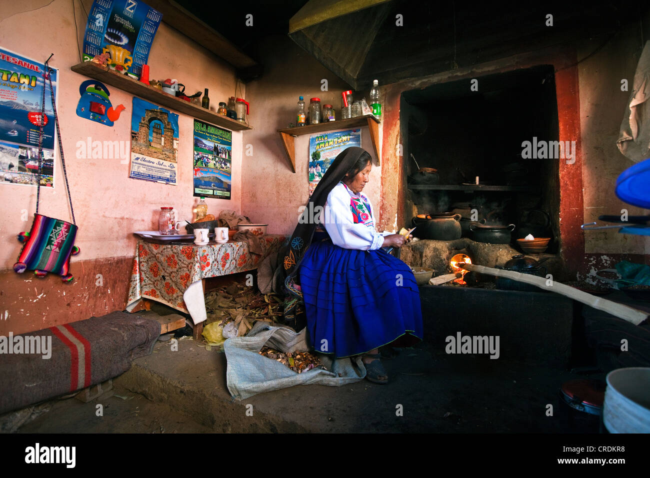 Hausfrau am Herd in ihrer Küche, die traditionelle Kleidung des Amantani-Quechua, Isla Amantani im Titicaca-See Stockfoto
