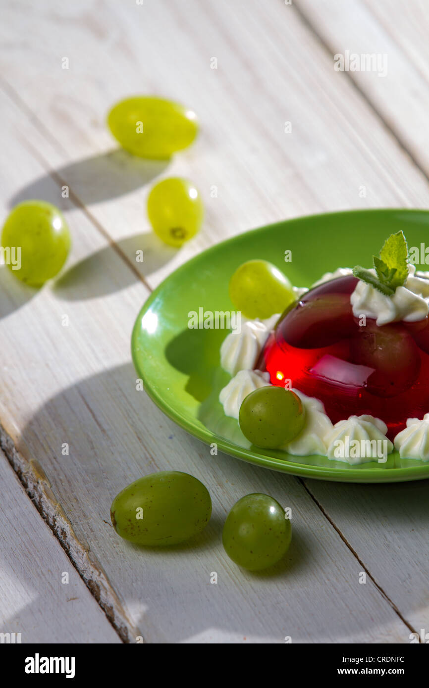 Rote Marmelade und Obst mit Sahne serviert Stockfoto