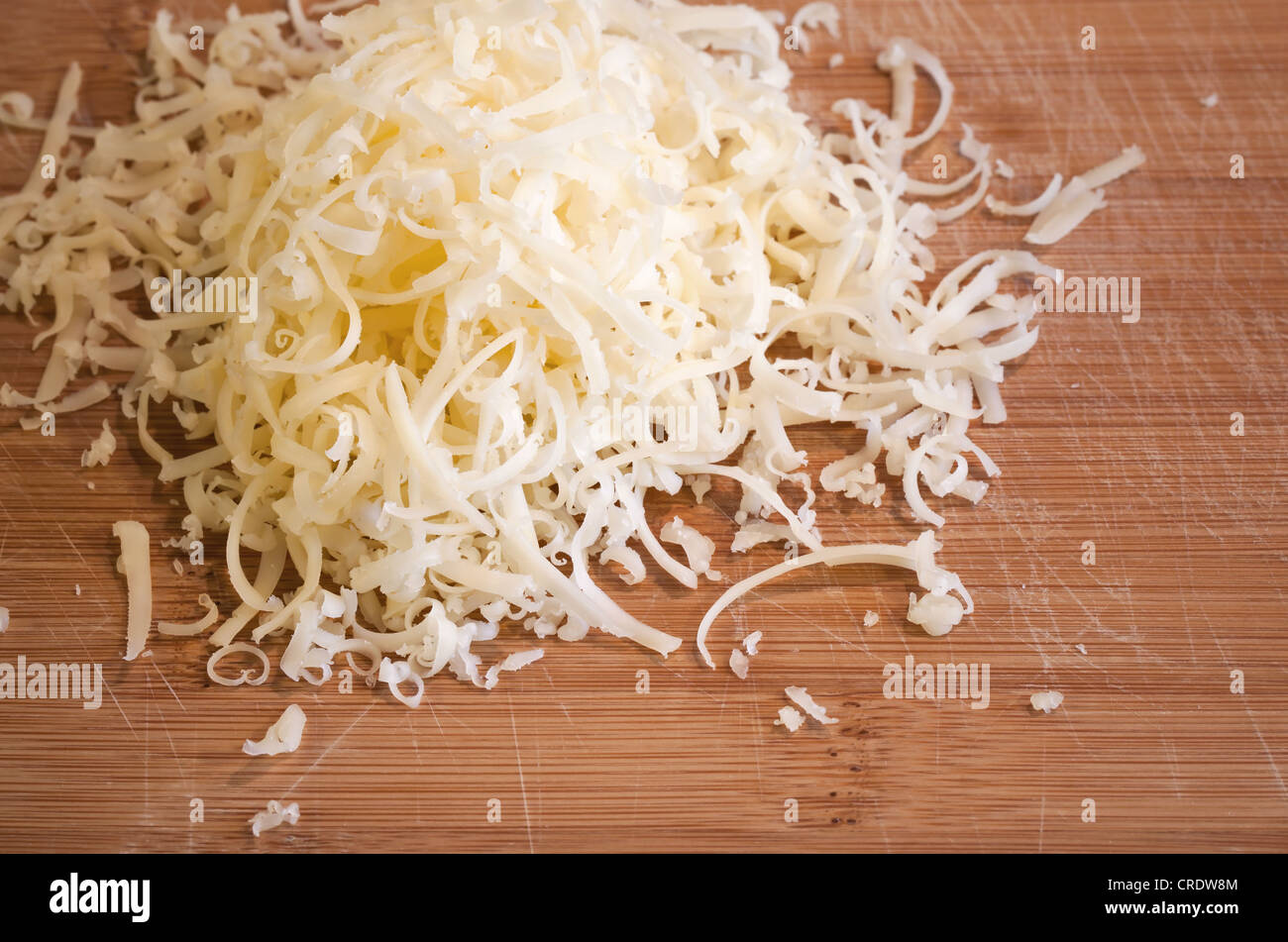 Haufen von frisch geriebenem Käse auf Holztisch Stockfoto