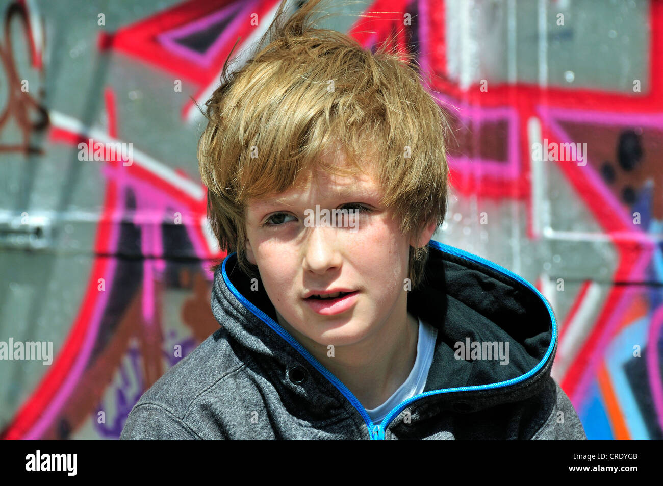 Junge, 11, vor einer Wand mit Graffiti, Porträt, Köln, Nordrhein-Westfalen, Deutschland, Europa Stockfoto