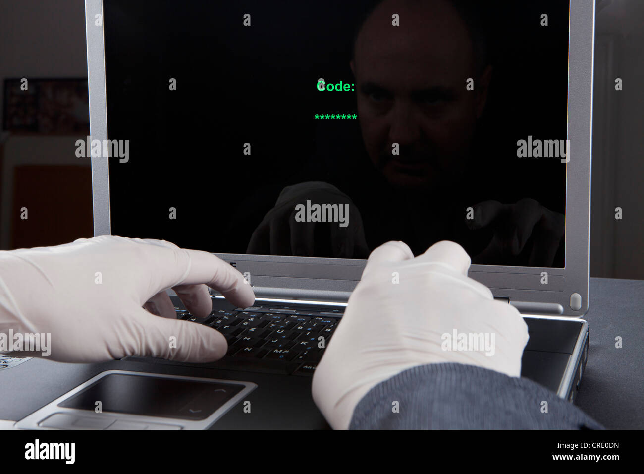 Hacker mit einem Laptop mit Latex Handschuhen um hinterlassen keine Spuren, symbolisches Bild für Internet-Kriminalität Stockfoto