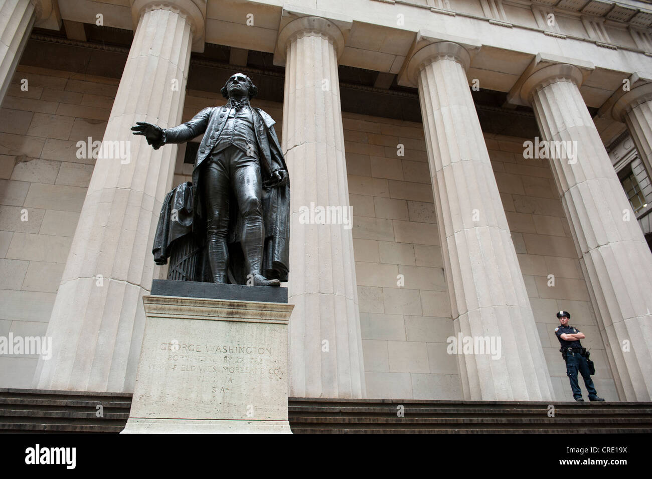 Statue von George Washington vor der Federal Hall National Memorial, mit einem Polizisten, Wall Street Stockfoto