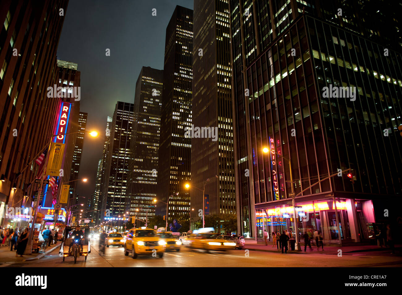 Beleuchtete Wolkenkratzer und Verkehr in der Nacht, 6th Avenue Ecke des 51. West, Midtown Manhattan, New York City, USA Stockfoto