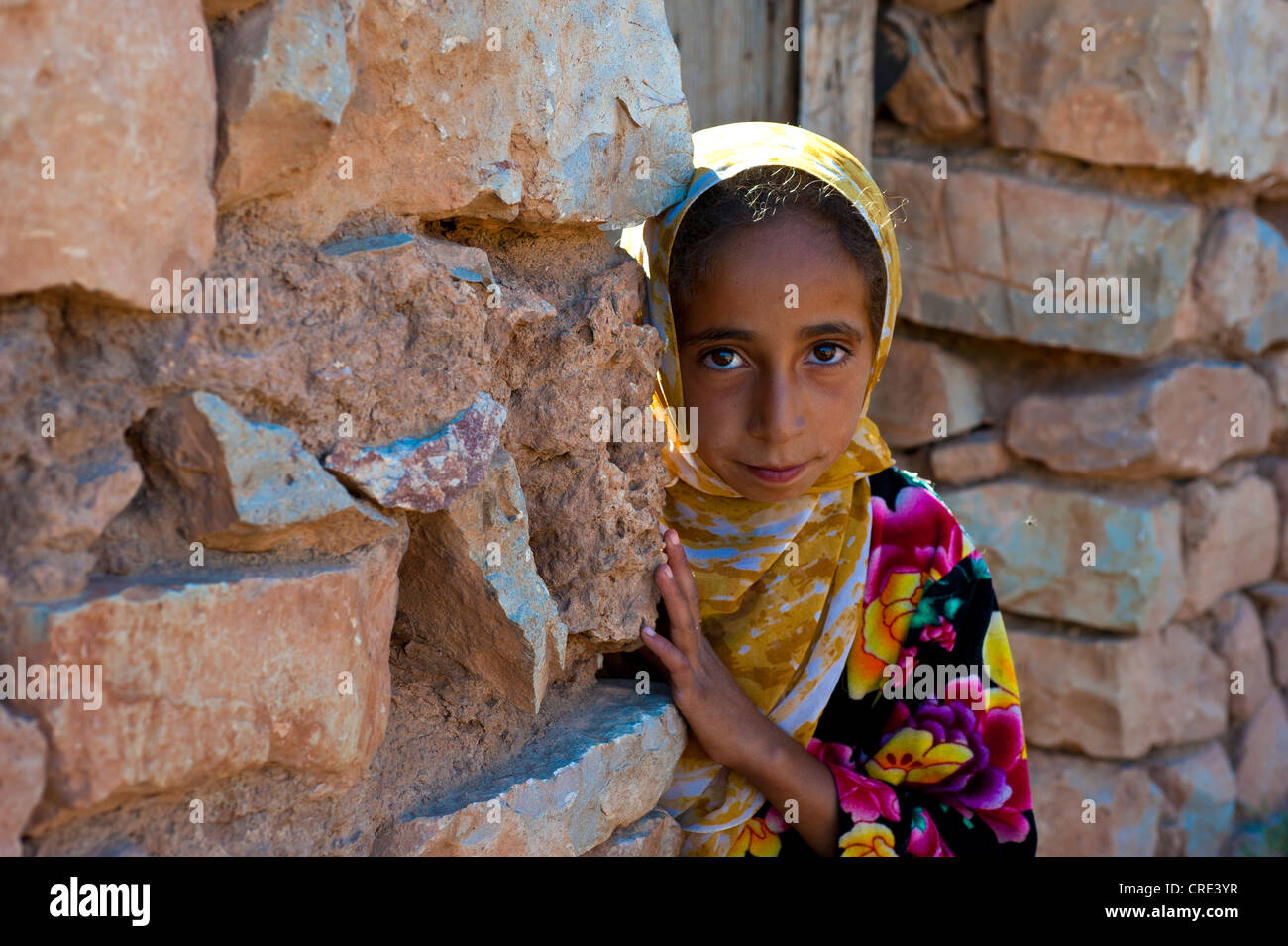 Junges Mädchen, Berberin, schauen neugierig hinter einer Wand, mittleren Atlasgebirge, Marokko, Afrika Stockfoto