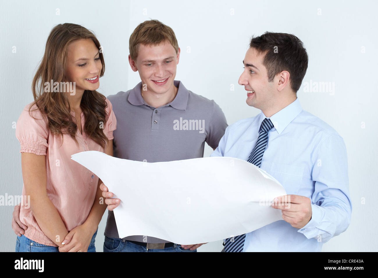 Männliche Architekten präsentieren den Plan des zukünftigen Hauses für die Familie mit zwei Stockfoto