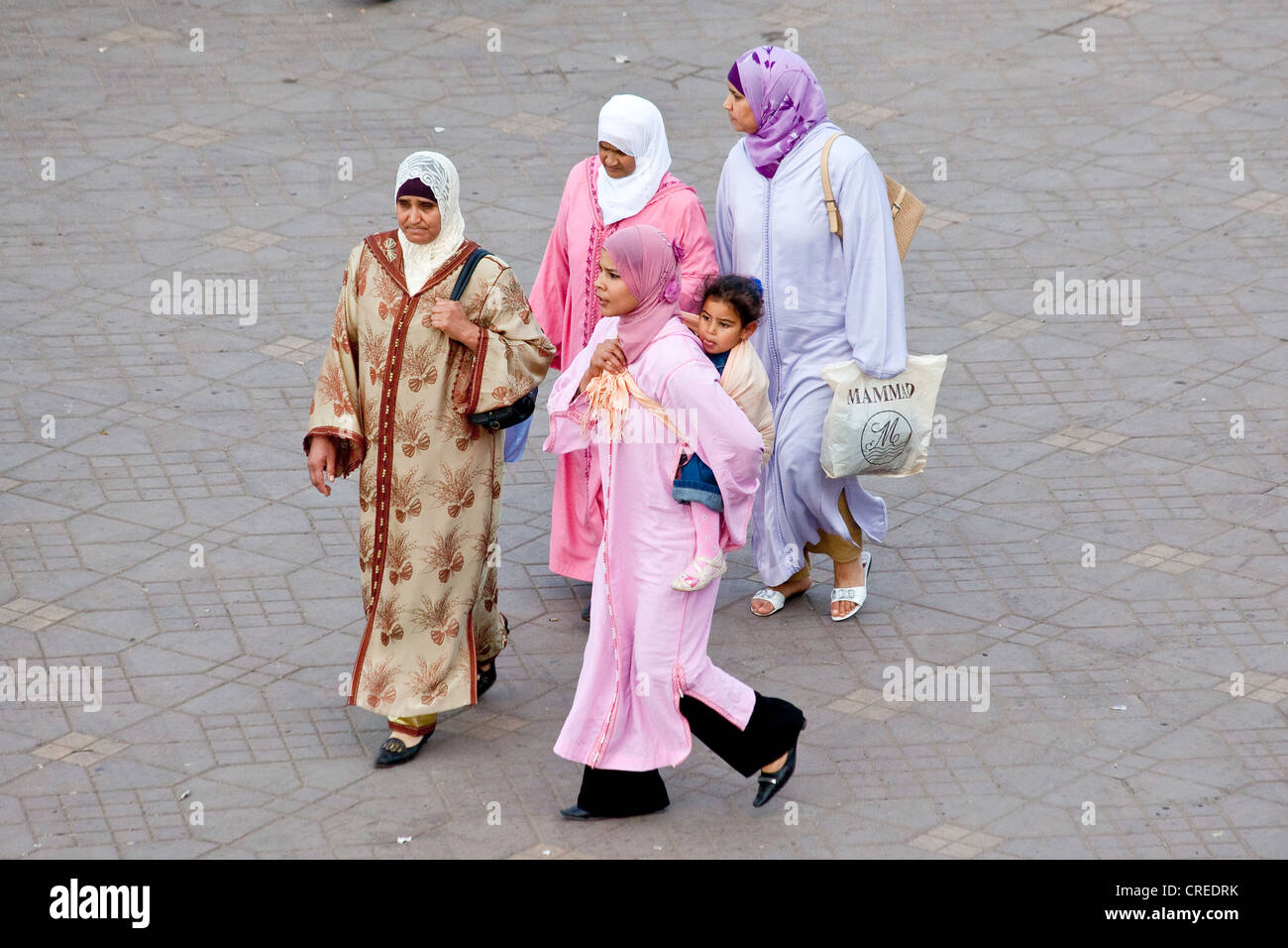 Frauen tragen traditionelle Djellabas Platz Djemaa El Fna, Medina oder Altstadt, UNESCO-Weltkulturerbe, Marrakesch, Marokko Stockfoto