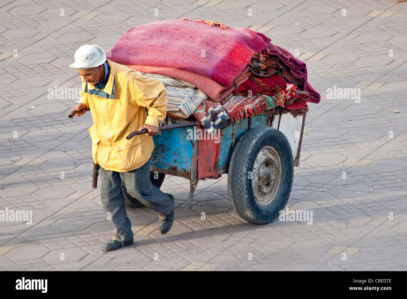Mann, die Transport von Teppichen mit einem Handwagen, Platz Djemaa El Fna, Medina oder Altstadt, UNESCO-Weltkulturerbe, Marrakesch Stockfoto