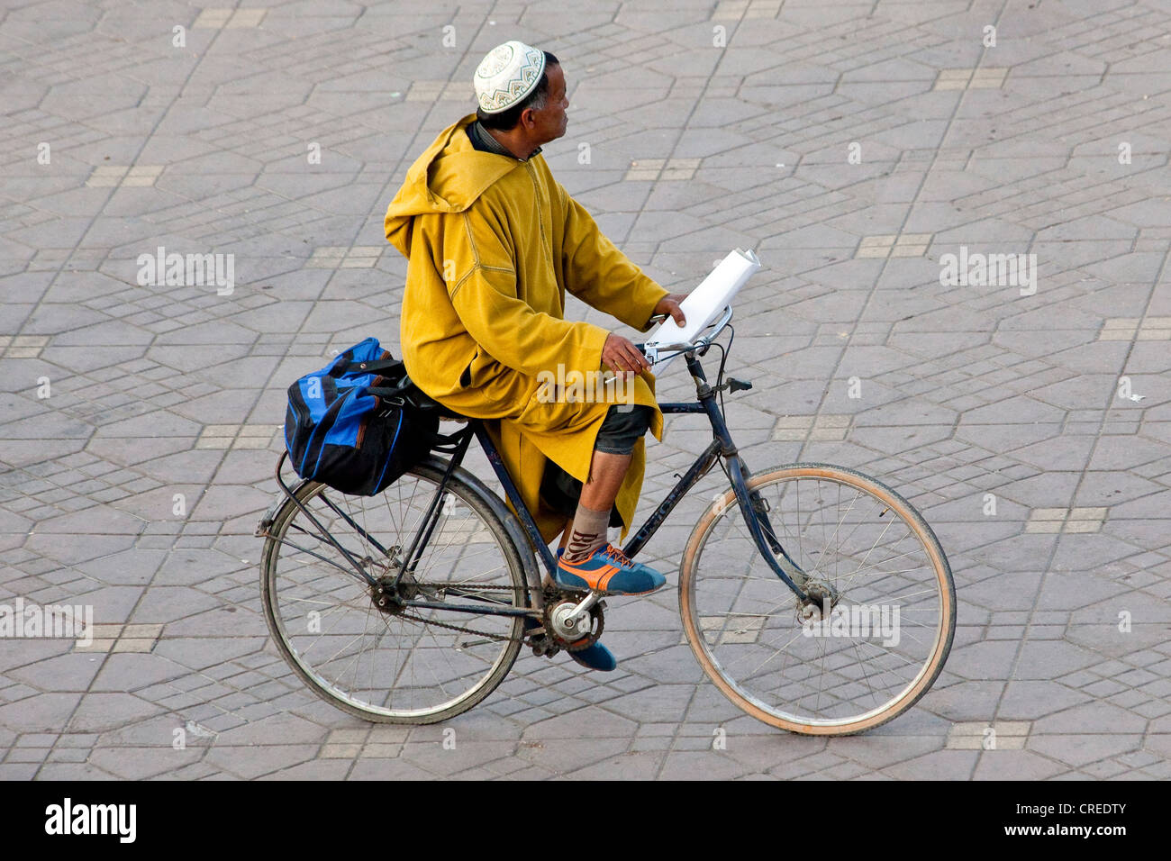 Mann trägt eine traditionelle Djellaba, mit dem Fahrrad in Djemaa El Fna Platz, Medina oder Altstadt, UNESCO-Weltkulturerbe Stockfoto