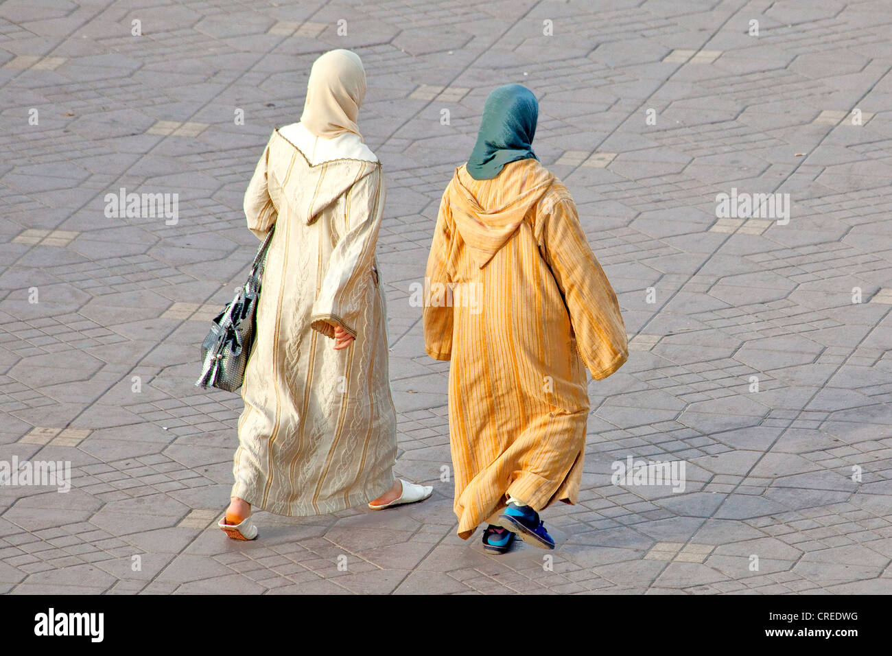 Zwei Frauen tragen traditionelle Djellabas Platz Djemaa El Fna, Medina oder Altstadt, UNESCO-Weltkulturerbe, Marrakesch Stockfoto
