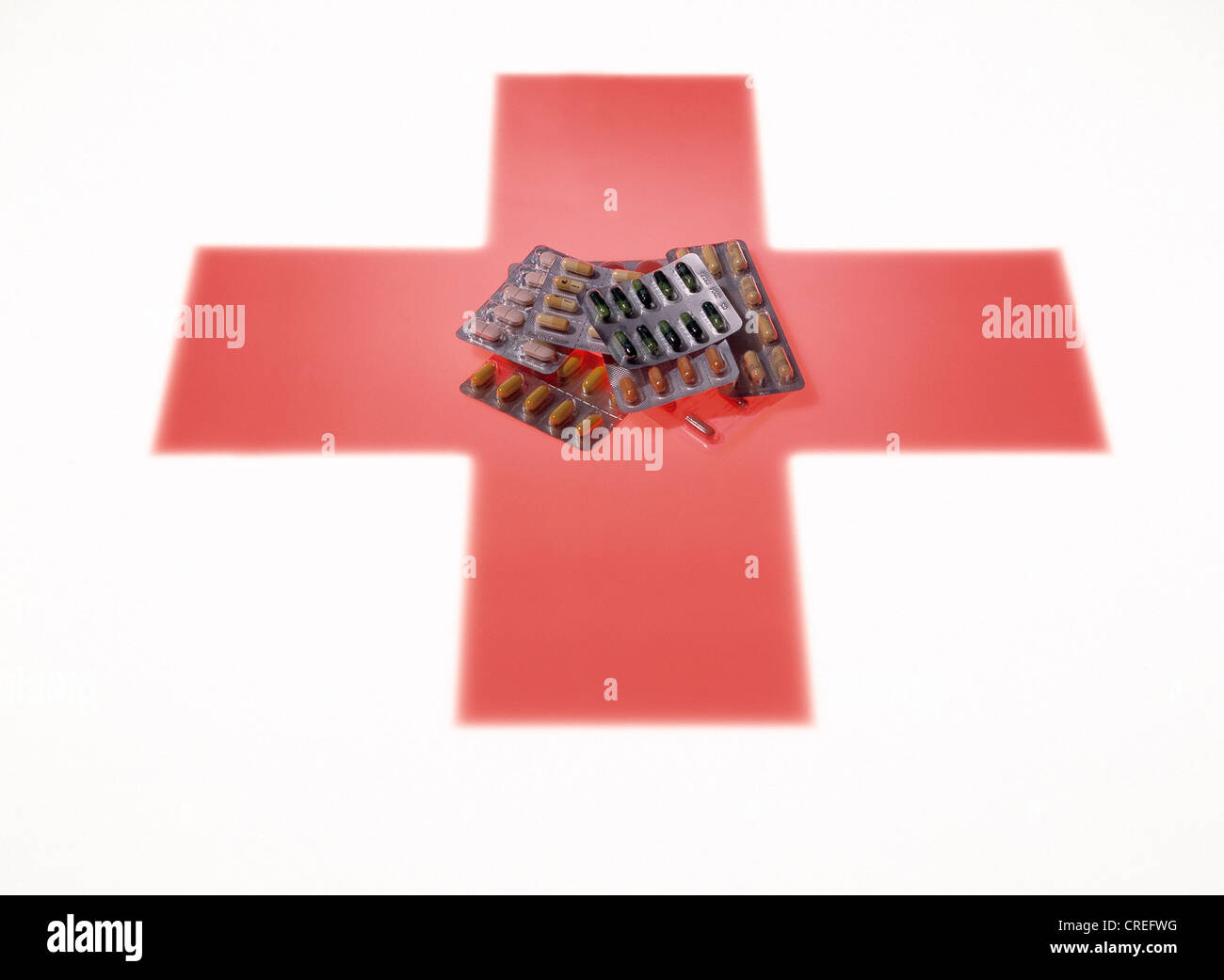 Tabletten in Blister-Packungen sind auf ein rotes Kreuz symbolisiert. Stockfoto