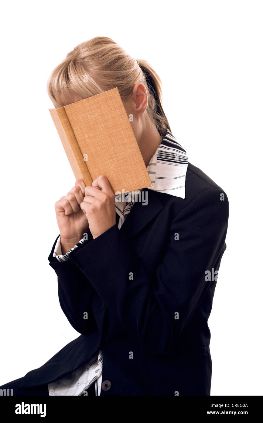 blonde Frau versteckt sich hinter einem Buch Stockfoto