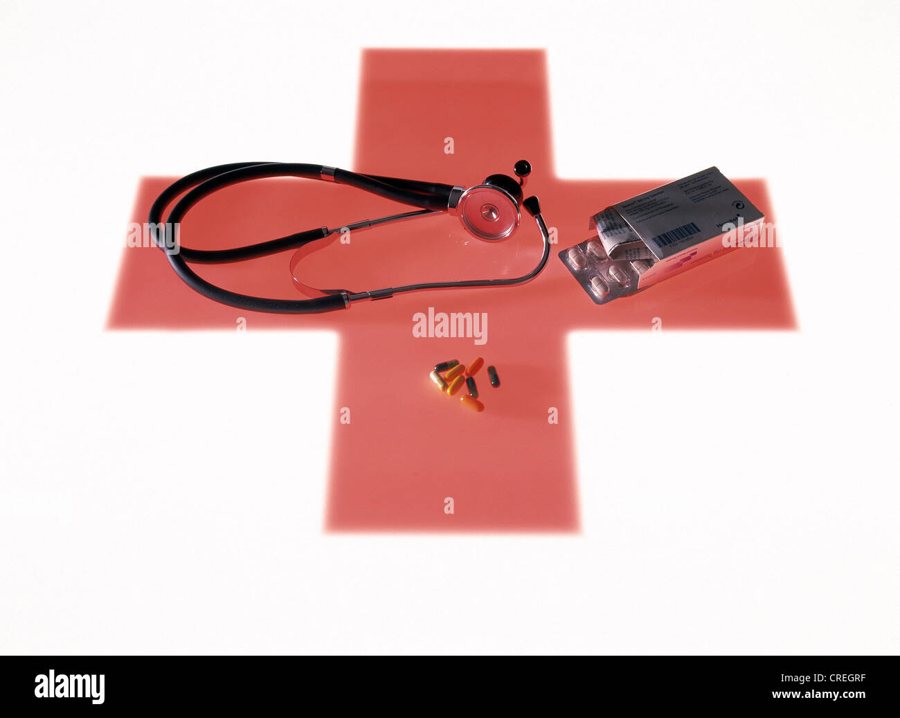 Verschiedene medizinische Utensilien auf ein rotes Kreuz als Symbol darunter liegend Stockfoto