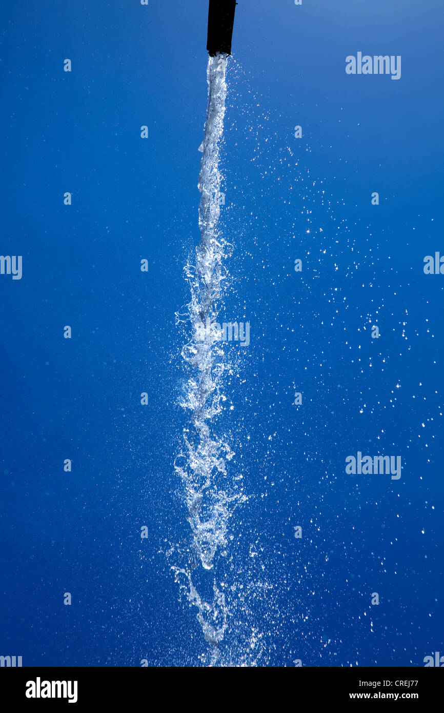 Ein Strahl des Wassers, das aus einem hochrangigen Brunnen vor dem blauen Himmel, in den Gärten des maurischen Königs Palast von Real Stockfoto