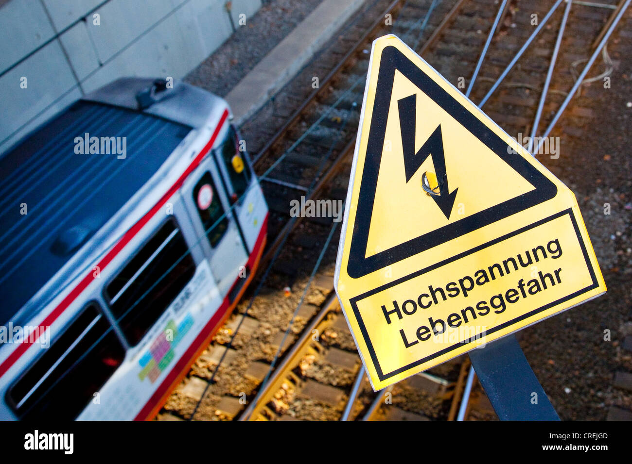 Schilder, Schriftzug "Hochspannung Lebensgefahr", Deutsch für "Hochspannung Lebensgefahr", auf einer Eisenbahnlinie von der s-Bahn Stockfoto