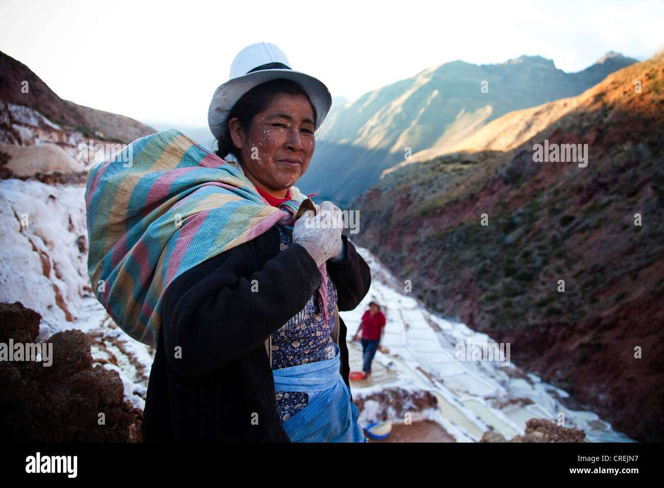 Ein Porträt einer Frau, die nach der Arbeit in der Salz-Pools in der Nähe von Maras im Heiligen Tal von Peru in die Kamera schaut. Stockfoto