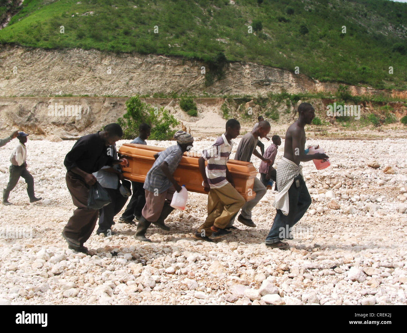 Männer tragen einen Sarg durch trockenes Flussbett im Norden Hait, Haiti, Artibonite Stockfoto