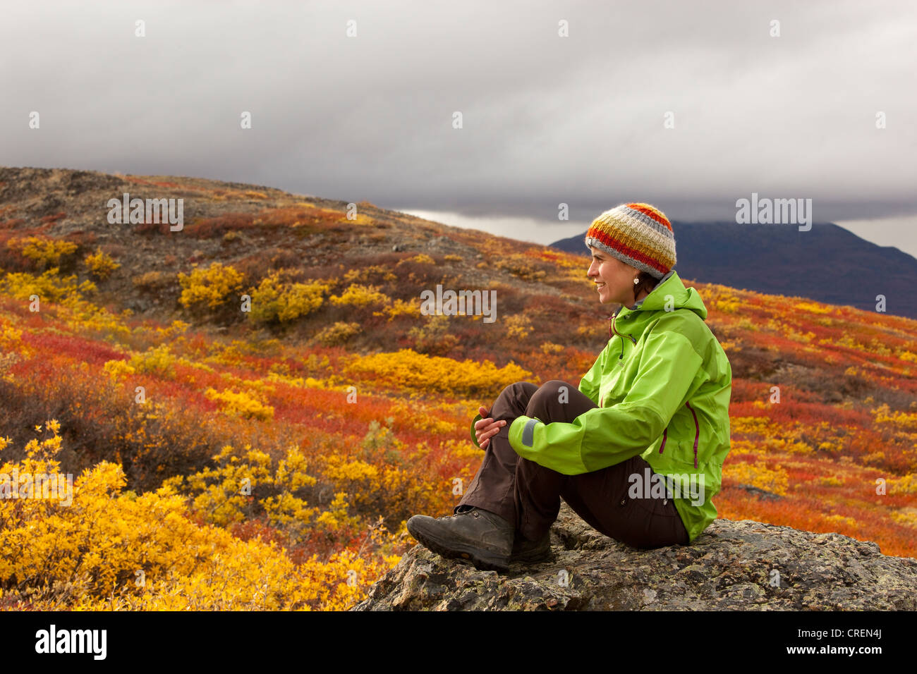 Junge Frau sitzt auf einem Felsen, ausruhen, genießen, Ansicht, subalpine Tundra, indischen Sommer, Herbst und in der Nähe von Fish Lake, Yukon-Territorium Stockfoto