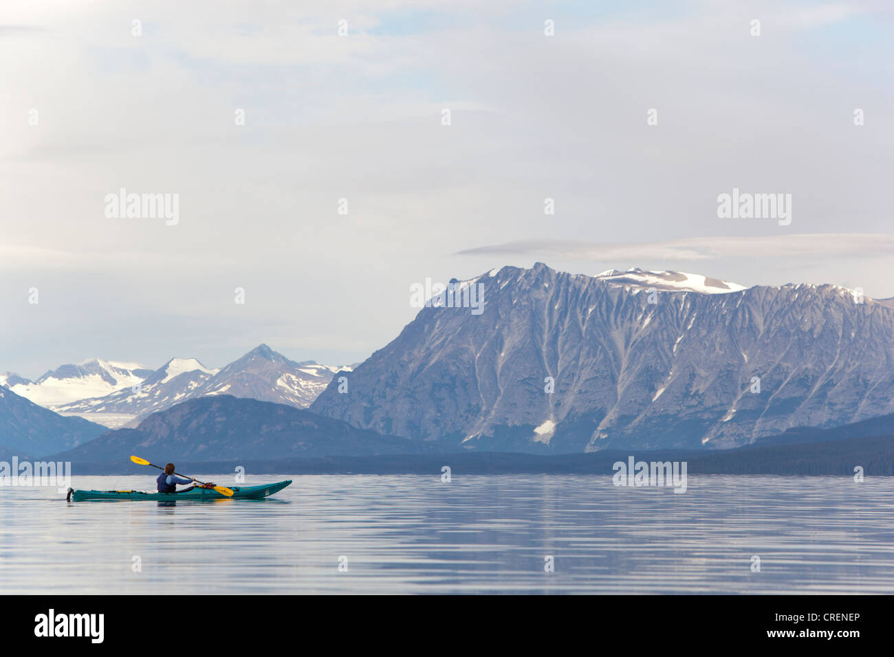 Frau in einem Kajak paddeln, Kajakfahren, Bergen im Hintergrund, Tagish Highland, Mount Fetterly, Atlin See, Britisch-Kolumbien Stockfoto