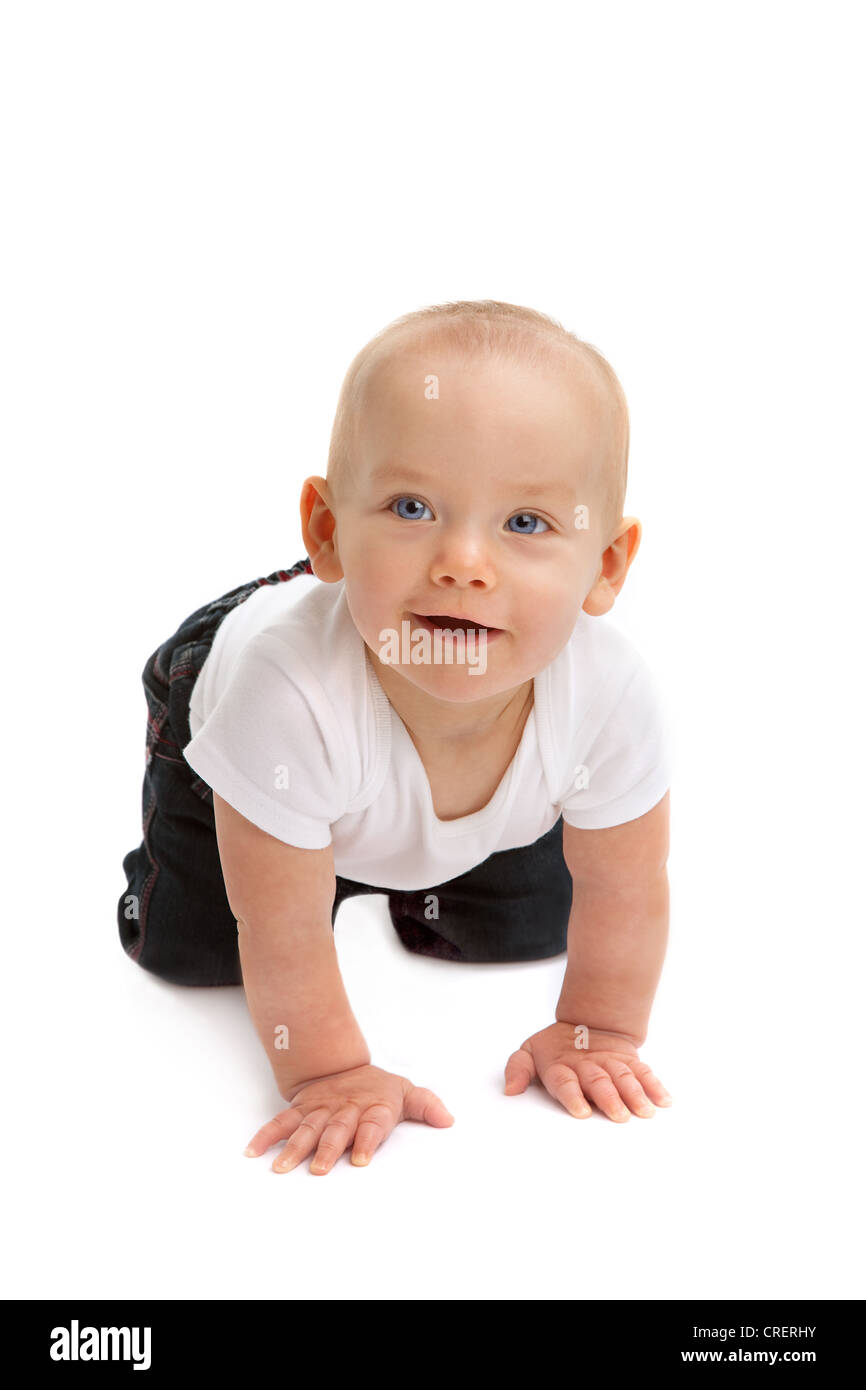 Glückliches Alarms 9 Monate altes Baby gekleidet in weißen Weste und blaue Jeans, vorwärts kriechen Stockfoto