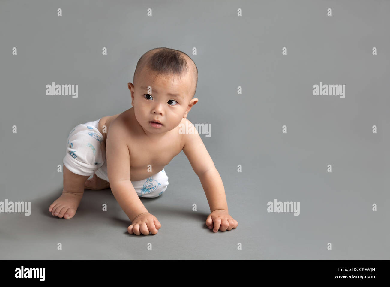 10 Monate alten chinesischen jungen, mit typischen chinesischen Baby Haarschnitt, kriechen Stockfoto