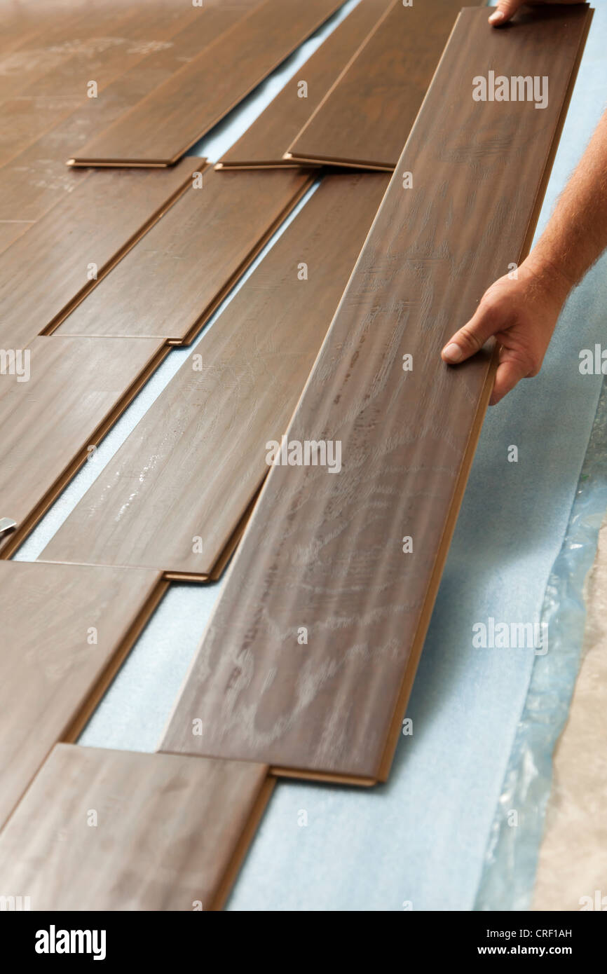 Mann, die Installation neuer Laminat Holzfußböden abstrakt Stockfoto