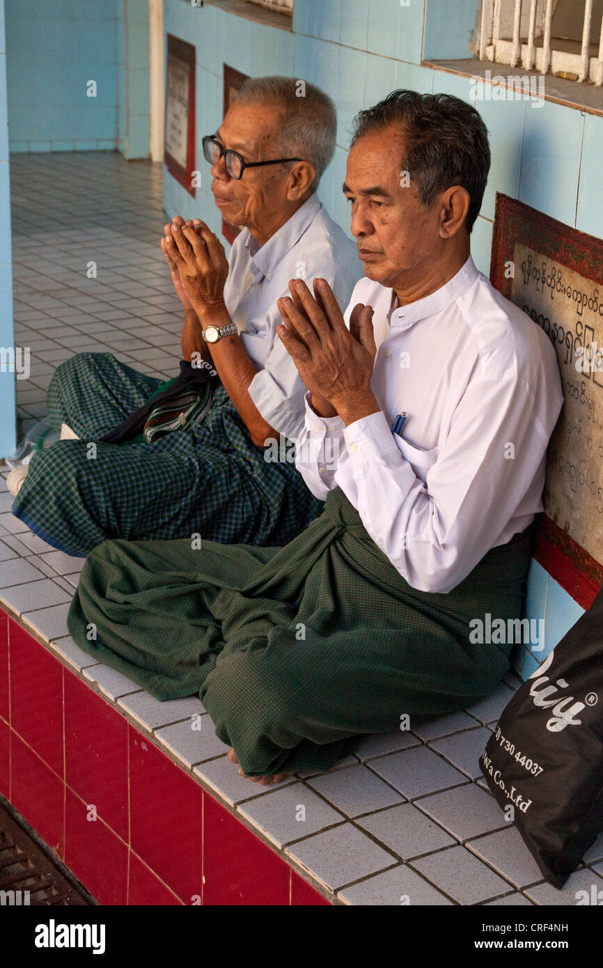 Myanmar, Burma, Yangon. Sule-Pagode. Zwei Männer im frühen Morgengebet. Stockfoto