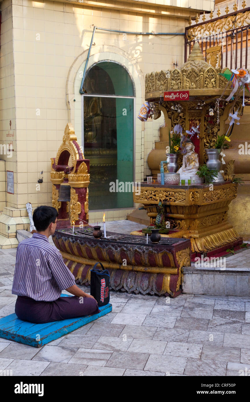 Myanmar, Burma, Yangon. Sule-Pagode. Am frühen Morgen Verehrer beten vor Buddha-Schrein. Stockfoto