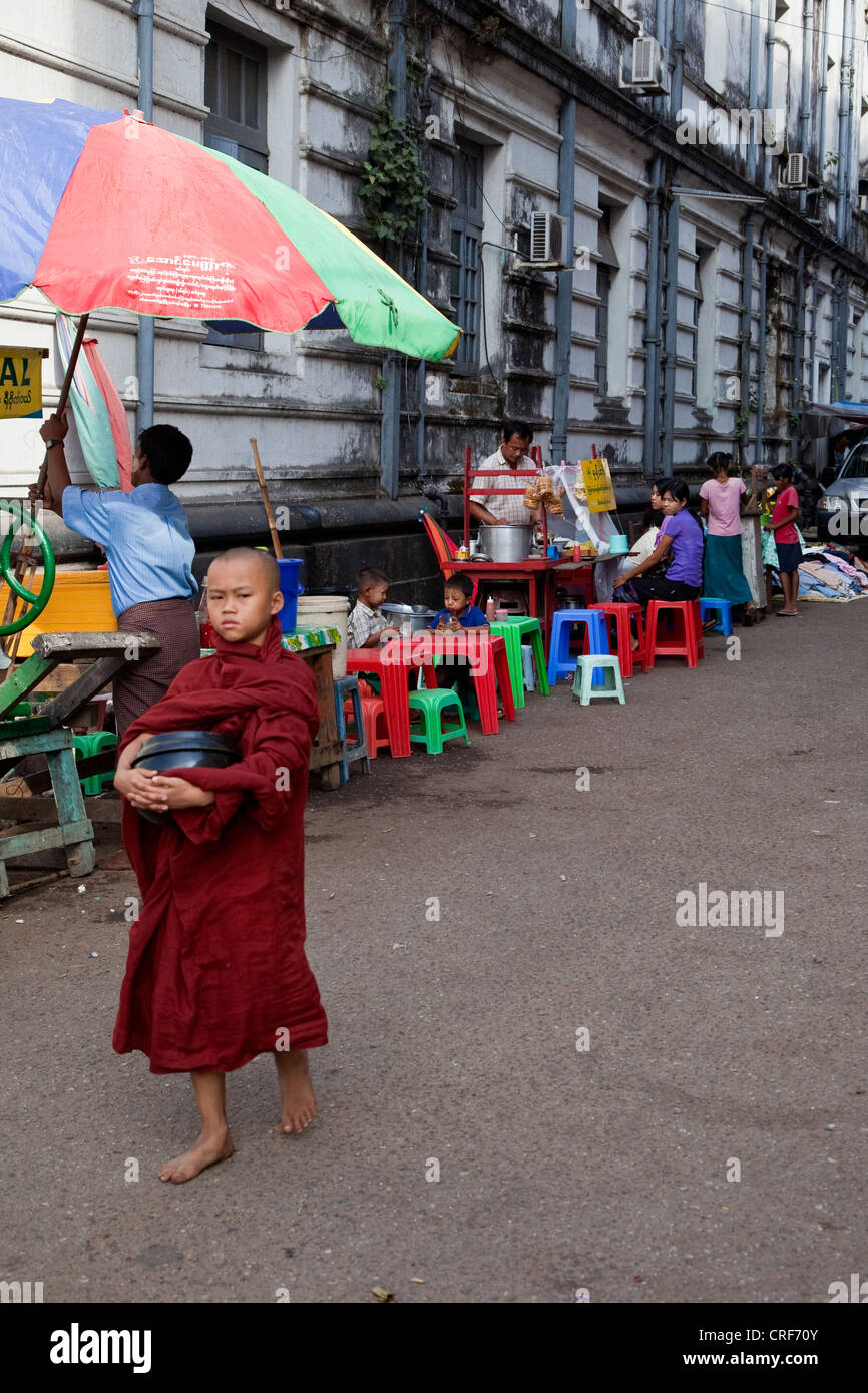 Myanmar, Burma, Yangon. Junger Mönch mit Lebensmittelspenden Schüssel erbetteln. Stockfoto