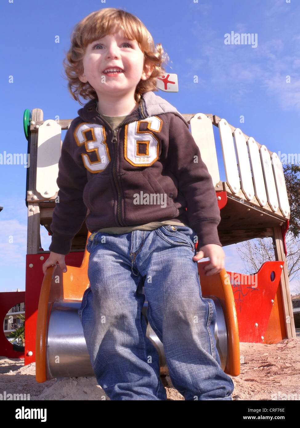 kleiner Junge stand vor einer Scheibe auf einem Spielplatz Stockfoto