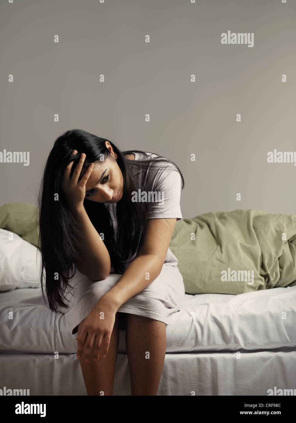 Depressive Frau sitzt am Bett Stockfoto