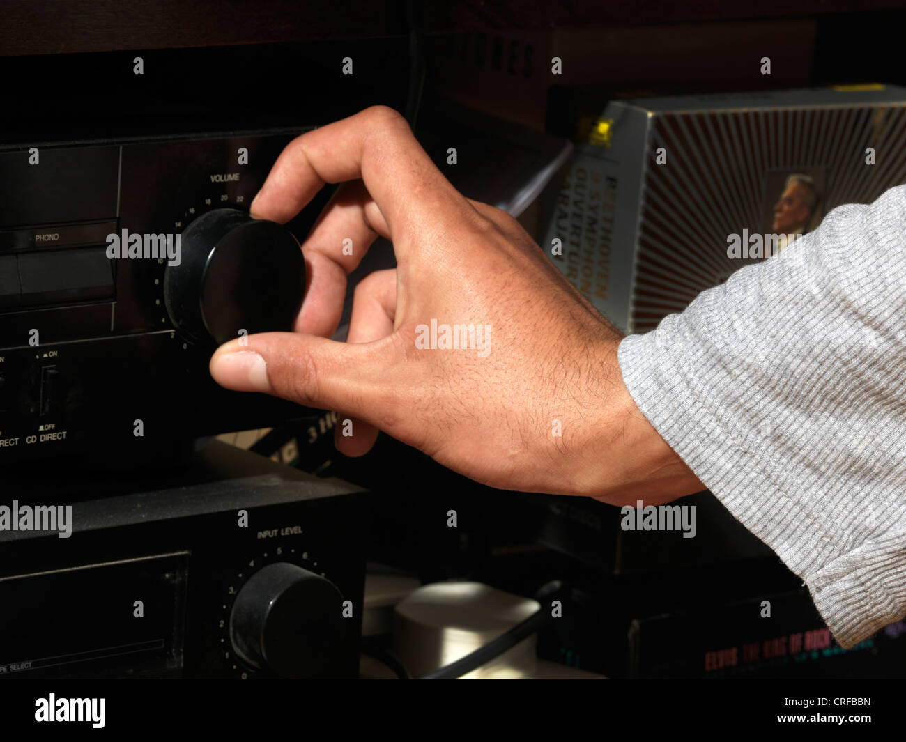 Afro-karibischen Mannes Hand drehen Lautstärkeregler auf eine HI-FI-System Stockfoto