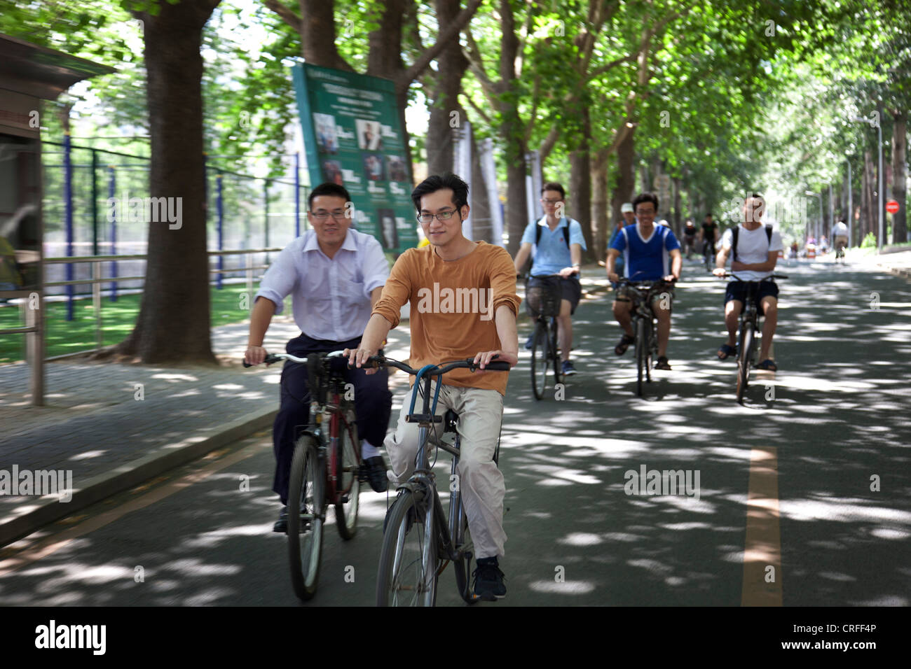 Studenten, Radfahren entlang der Straße auf dem Campus an der Tsinghua Universität in Peking, China. Eines der C9-League-Universitäten. Stockfoto