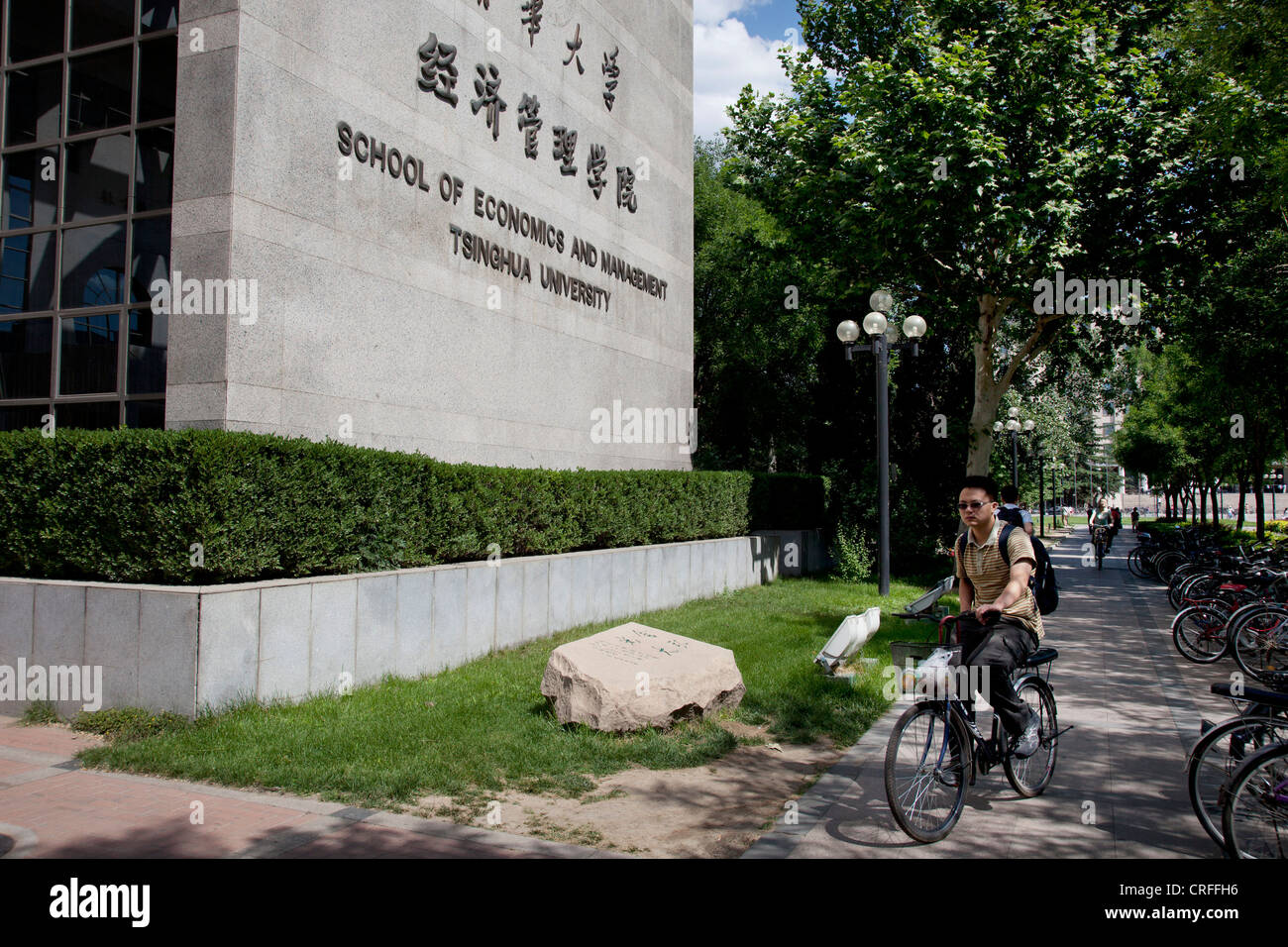 Student Radfahren vorbei an wirtschaftswissenschaftlichen Gebäude auf dem Campus an der Tsinghua Universität in Peking, China. Ein C9-League-Universität. Stockfoto