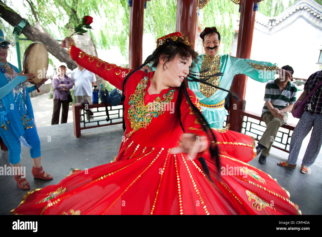 Menschen gekleidet in traditioneller Kleidung Tanz zusammen in einer Form, die auch eine Geschichte erzählt. Beihai-Park, Peking, China. Stockfoto