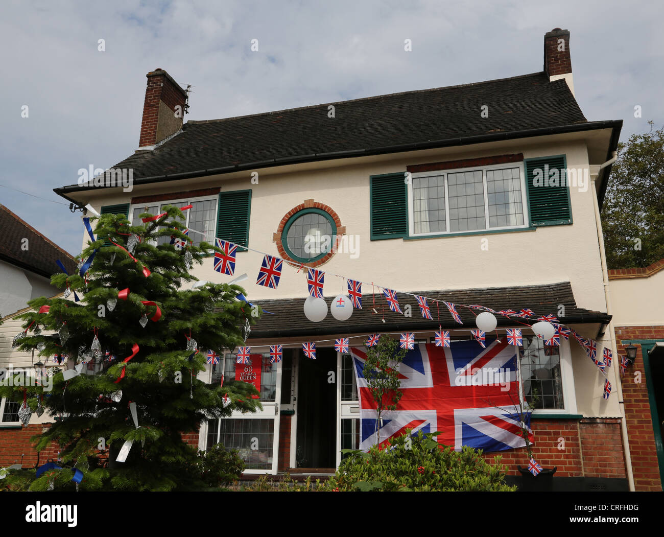 Haus, geschmückt mit Girlanden und Union Jack-Flaggen feiert die Königin Diamond Jubilee an A Street Party Surrey England Stockfoto