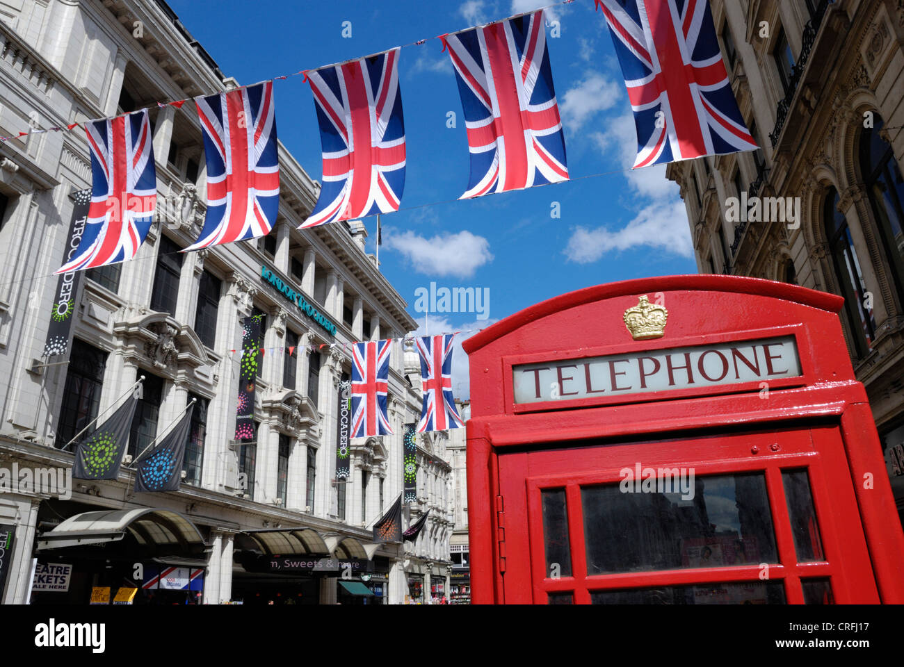 Union Jack-Flaggen und rote Telefonzelle in der Nähe des Trocadero, Picadilly Circus, London, UK Stockfoto