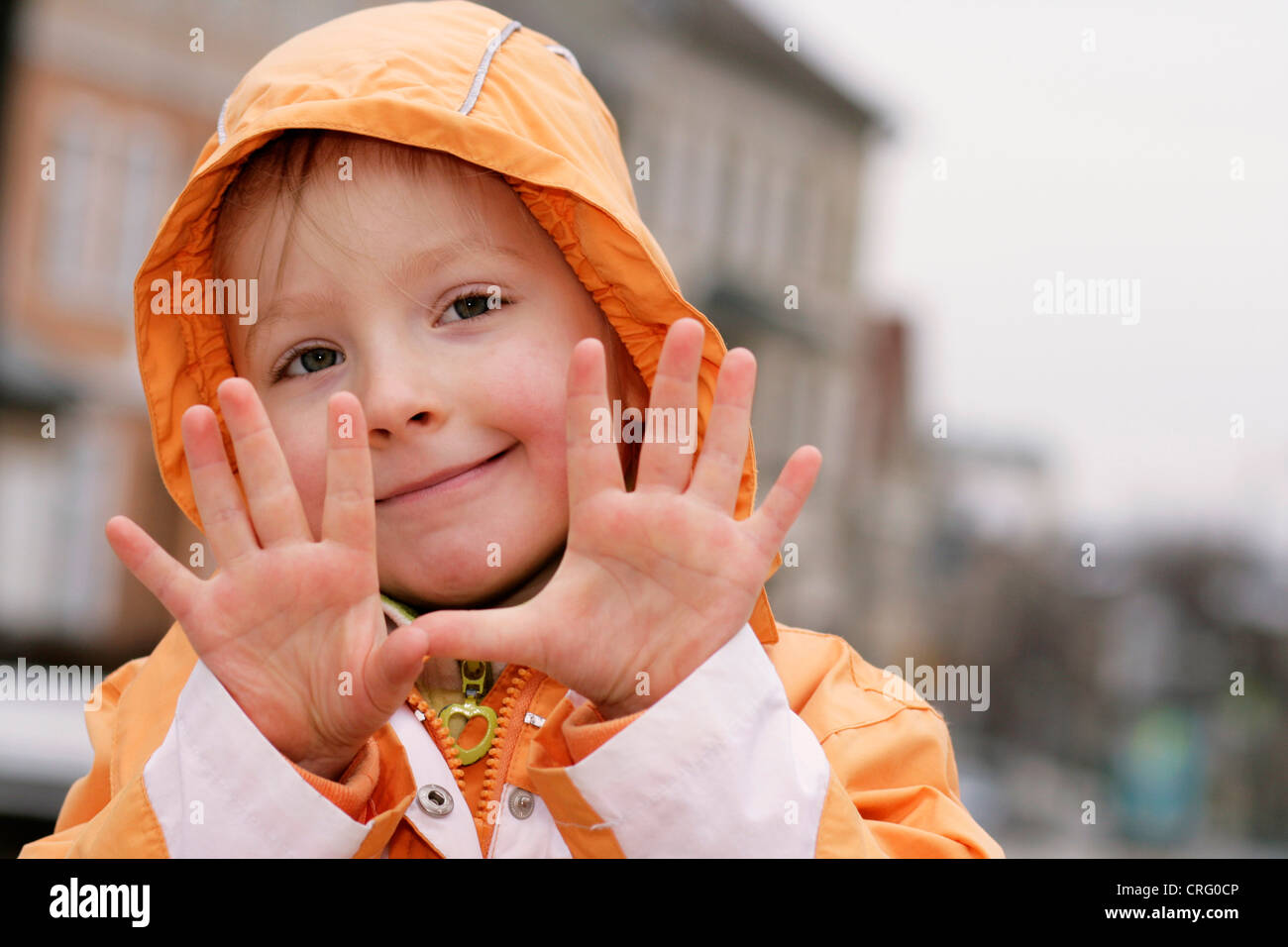 kleines Mädchen mit Kapuze macht Grimassen, Deutschland Stockfoto