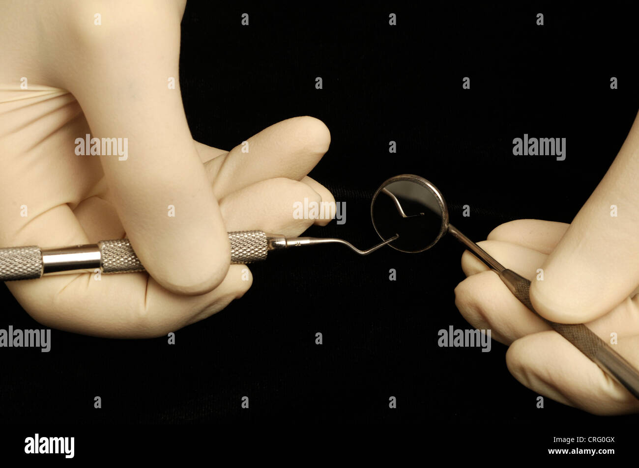 Behandschuhte Händen halten Sie eine doppelseitige dental Pick- and -Mundspiegel. Stockfoto
