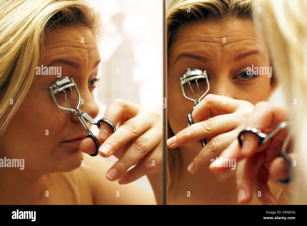blonde Frau, die anziehen ihre Augen Make-up Stockfoto blonde Frau, die anziehen ihre Augen Make-up Stockfoto