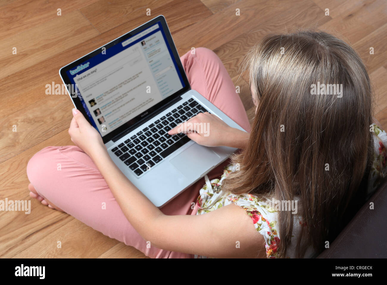 Junge Frau mit ihrem Laptop auf Twitter. Stockfoto