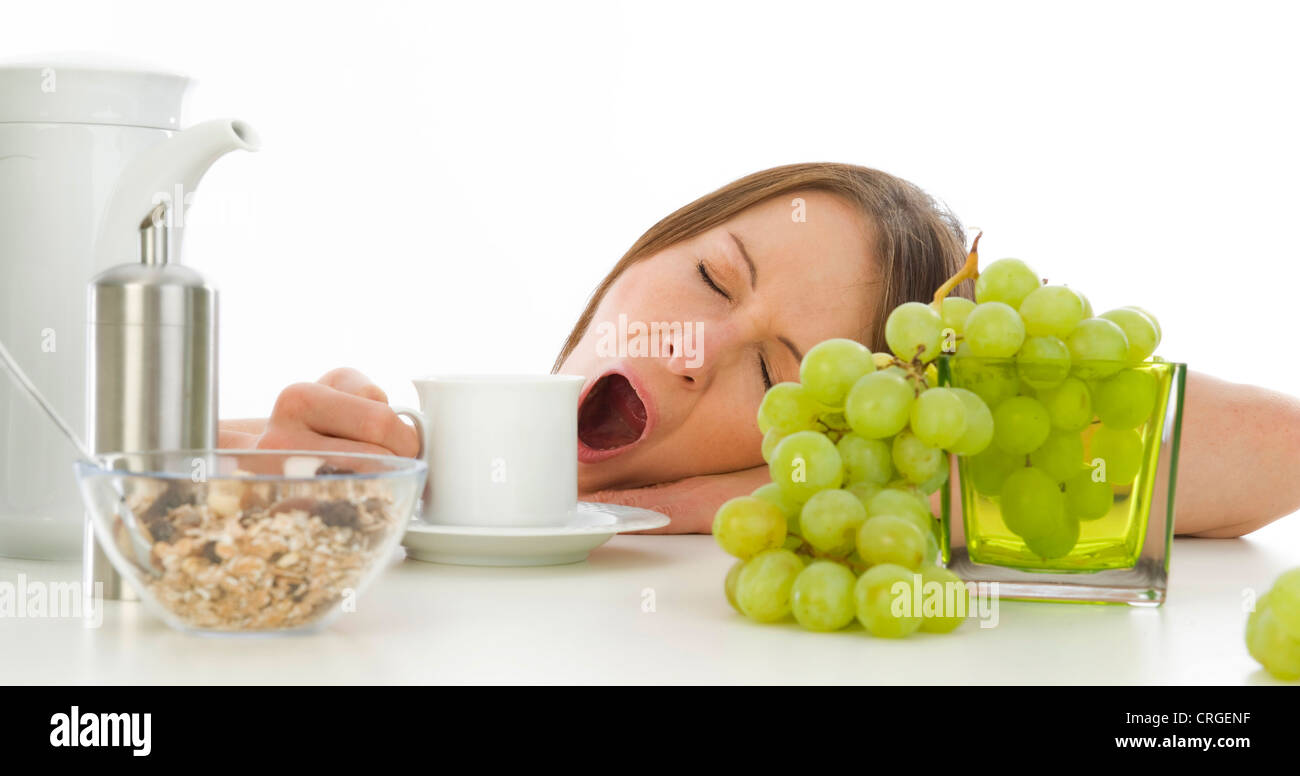 müde Frau Gähnen beim Frühstück Stockfoto