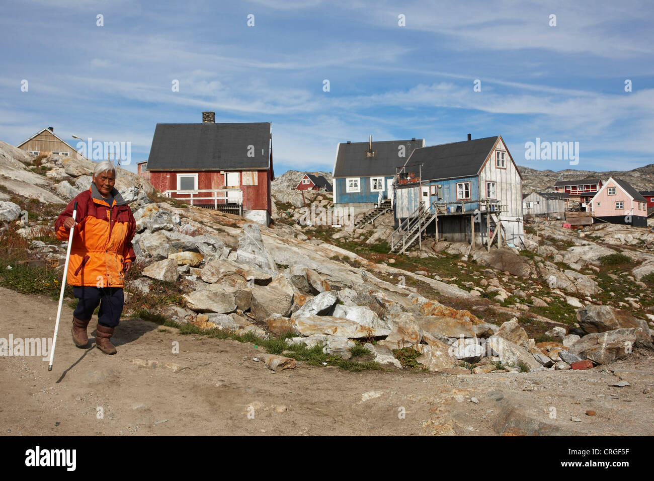 ältere Inuit-Frau vor Holzhäuser, Grönland, Ammassalik, Ostgrönland, Tiniteqilaq Stockfoto